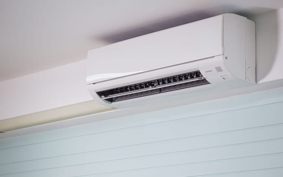 Split AC mounted high on a living room wall