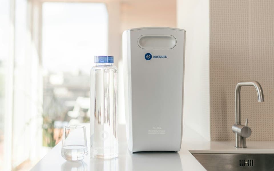 Water purifier on a kitchen counter next to the tap